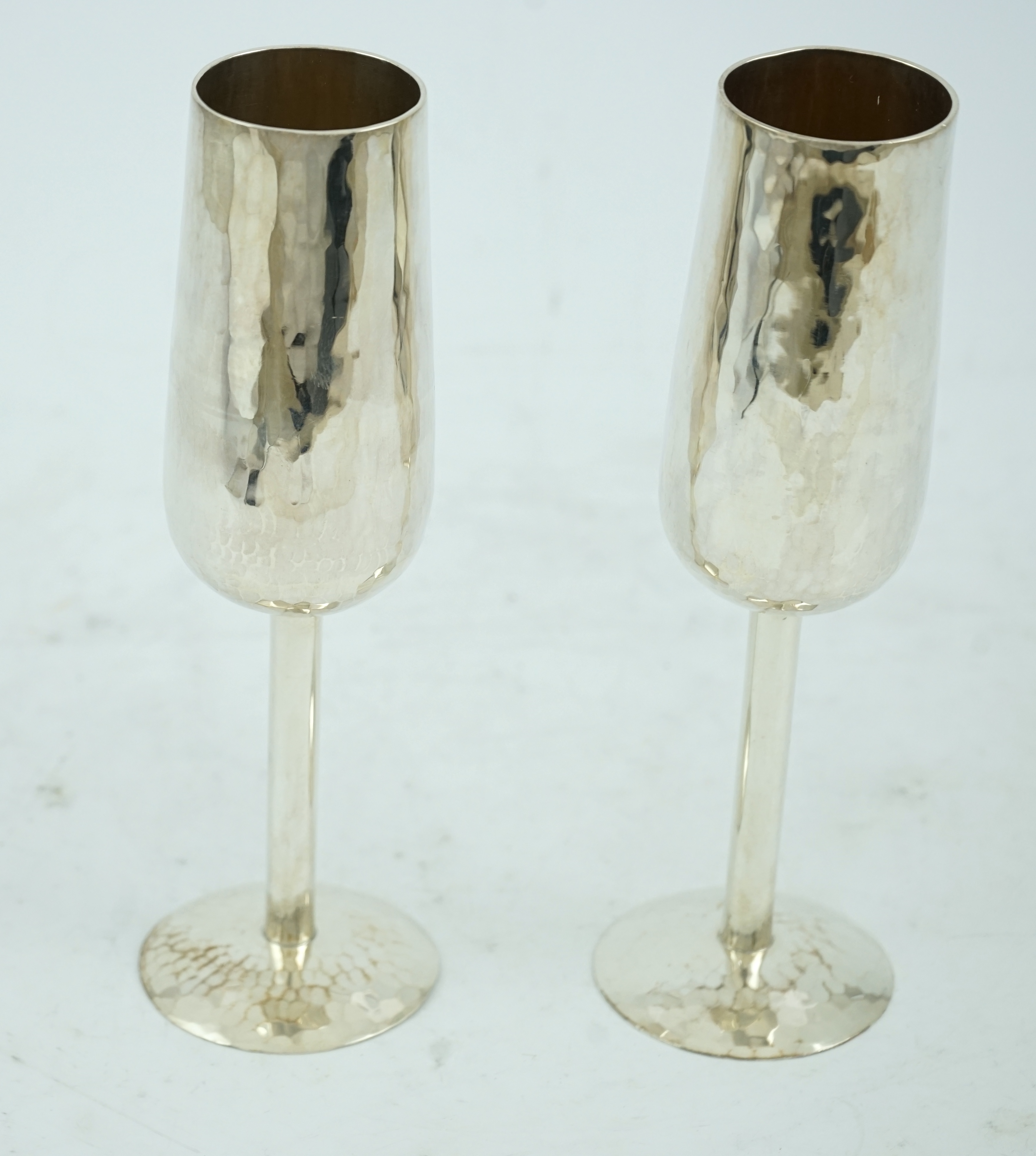 A pair of Elizabeth II planished silver champagne flutes, by Pruden & Smith